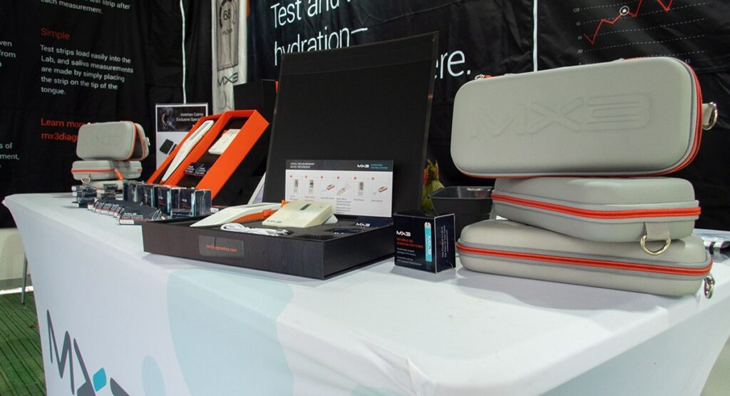 A table with MX3 branded hydration testing kits and accessories on display.